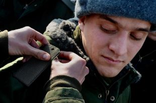Призывник во время примерки военной формы.