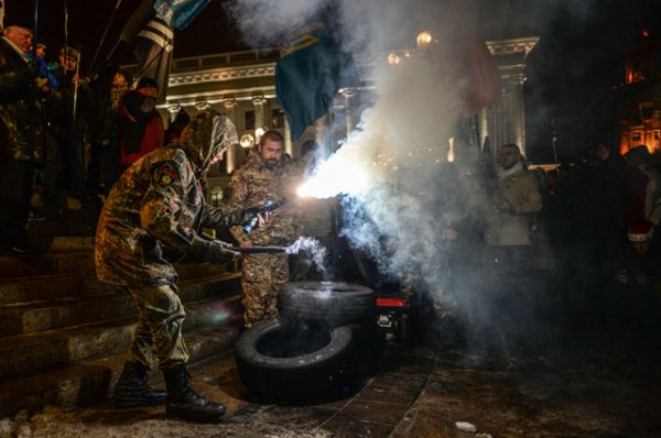Участники акции, посвященной годовщине начала событий на Майдане, жгут файеры в Киеве.
