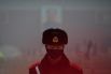 Военный полицейский в маске стоит на страже перед портретом покойного председателя Мао на площади Тяньаньмэнь в Пекине.