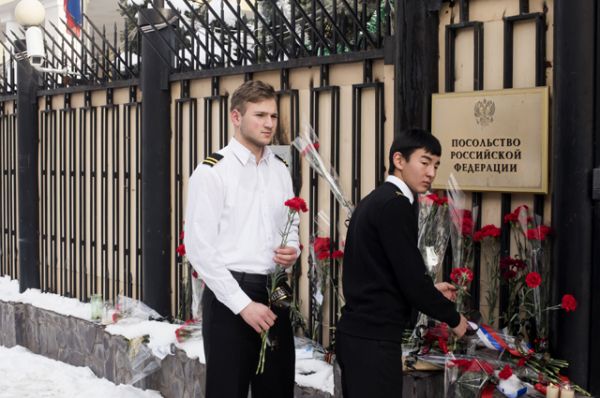 Жители Бишкека приносят цветы к посольству России в память о погибших при крушении самолета Ту-154.