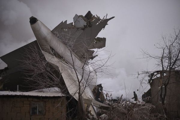 На этом фото видно, что поврежденный хвост самолета застрял в жилом здании