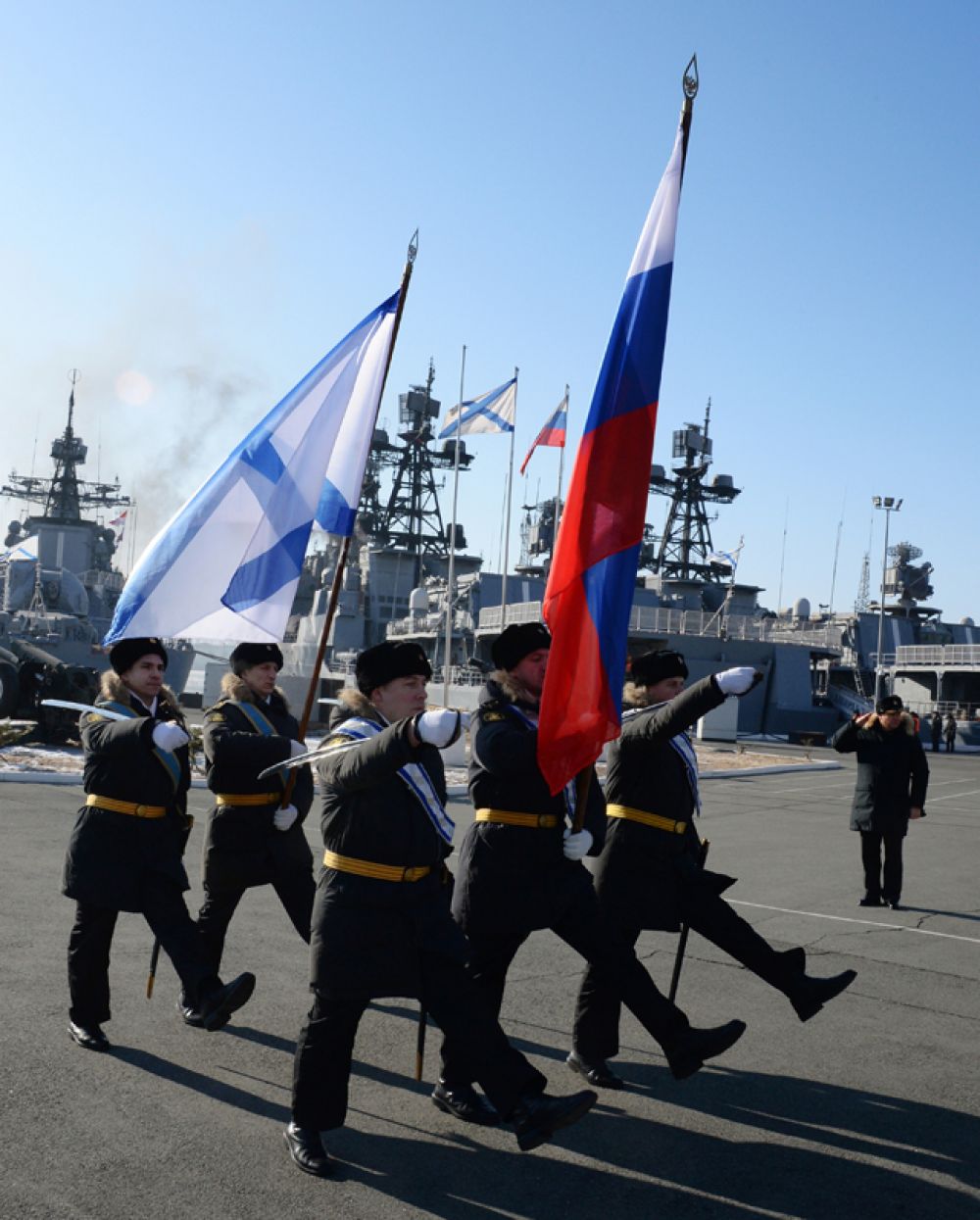 Вынос Российского и Андреевского флагов во время торжественной встречи отряда боевых кораблей Тихоокеанского флота в составе большого противолодочного корабля «Адмирал Трибуц» и большого морского танкера «Борис Бутома», вернувшихся во Владивосток из дальнего похода.
