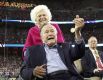 Бывший президент США Джордж Буш и его супруга Барбара Буш на поле перед началом игры.