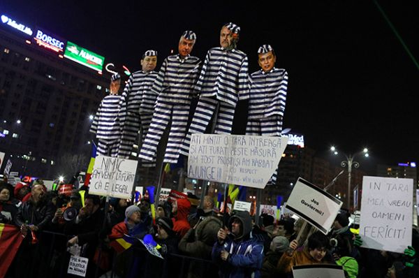 В руках у протестующих румынские флаги и плакаты, на которых написано «Аннулируйте постановление», у некоторых — картонные куклы в виде некоторых членов кабинета в тюремных робах. 