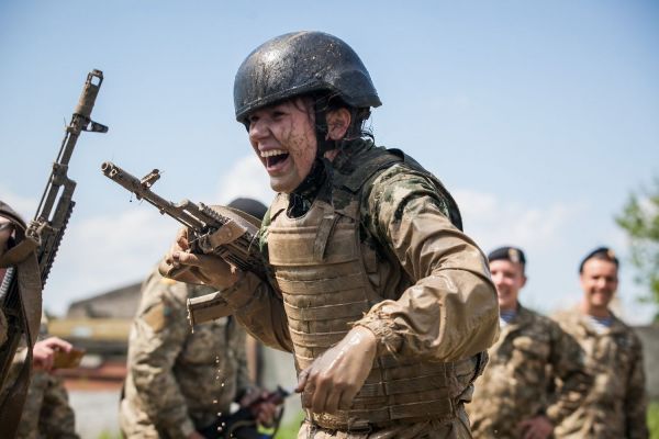 Девушка-военная улыбается во время бега с препятствиями. Фото из номинации «Люди»