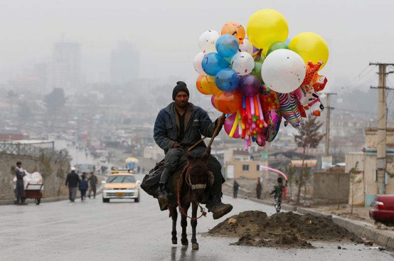 Афганский мужчина едет на осле на празднование Навруза в Кабуле.