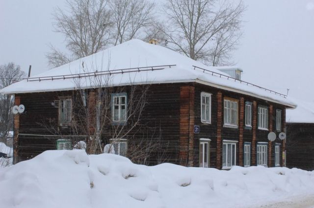 В городе началась оттепель, и снег падает с неочищенных крыш частных домов