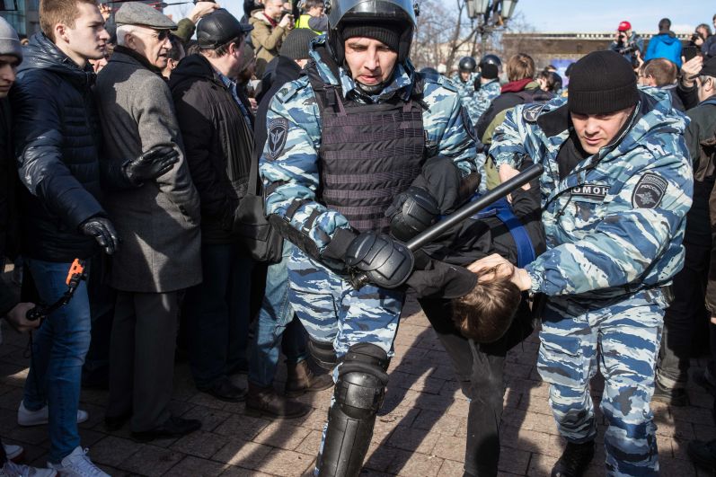 ОМОН ведет задержанного в автозак