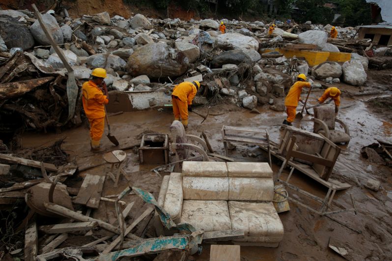 Спасатели ищут тела в разрушенном районе после наводнений и оползней.