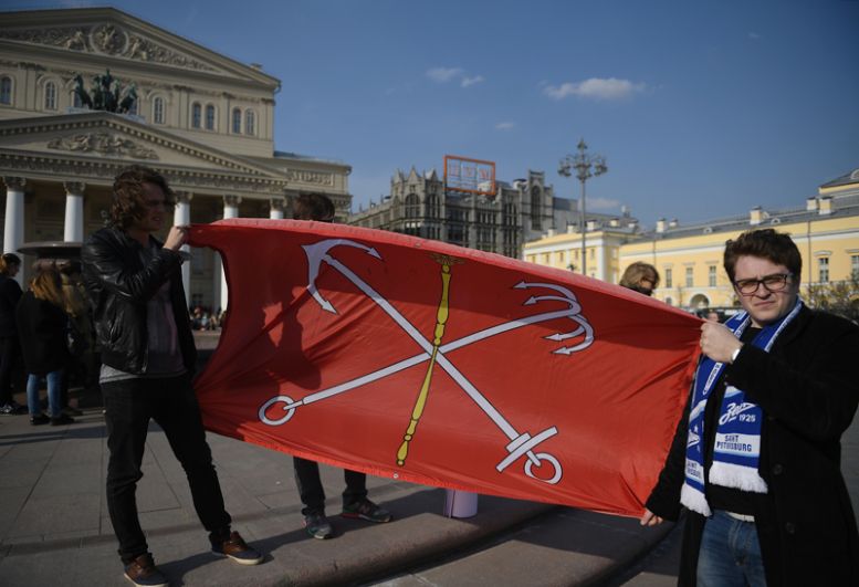 Участники акции памяти и солидарности «Питер — Мы с тобой!» в Москве держат флаг Санк-Петербурга.