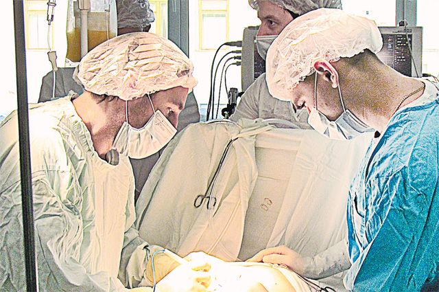 «Во время такой длительной операции хирургу не так сложно, как ассистентам», - говорит доктор Ложкин (слева).