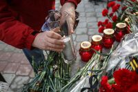 Житель ставит свечу в память о жертвах террористических актов 2013 года в Волгограде.