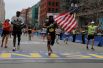 Американский бегун Хосе Санчес с флагом своей страны во время 121-го Бостонского марафона.