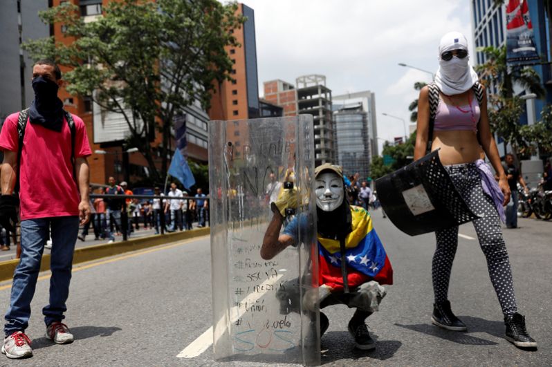 Демонстранты во время митинга против президента Венесуэлы Николаса Мадуро в Каракасе.
