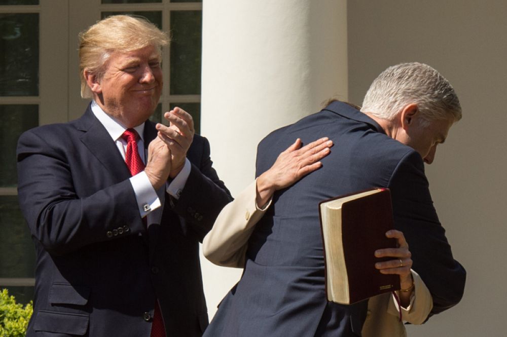10 апреля. Дональд Трамп наблюдает за верховным судьёй США Нилом Горсачем, как тот обнимает свою супругу после принятия присяги в Розовом саду Белого Дома.