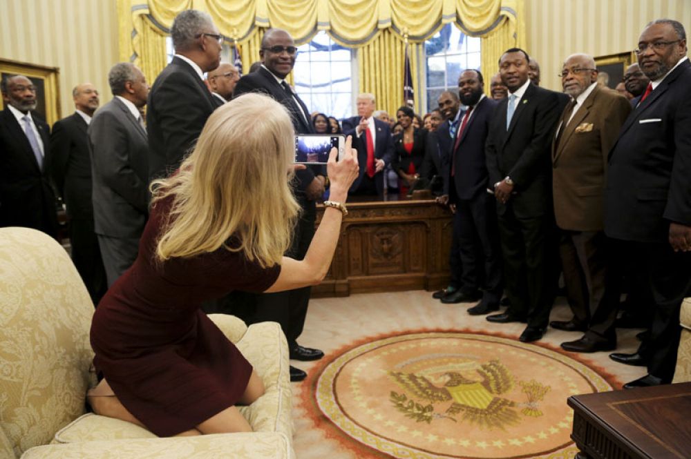 27 февраля. Советник президента Келлиэнн Конуэй фотографирует Дональда Трампа и руководителей ВУЗов, созданных для обучения афроамериканцев, во время встречи в Овальном кабинете Белого дома.