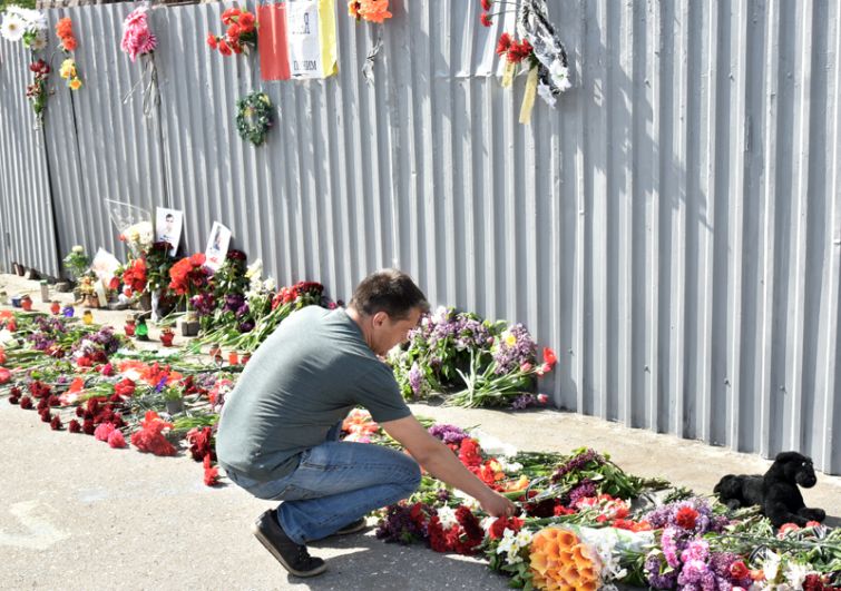Мужчина возлагает цветы во время акции в память о погибших при пожаре в Доме профсоюзов на площади Куликово поле в Одессе.