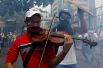 8 мая. Участник митинга против президента Николаса Мадуро в Каракасе играет на скрипке.