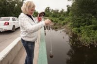 Наталия Лопанцева замеряет уровень воды в одном из ериков поймы.