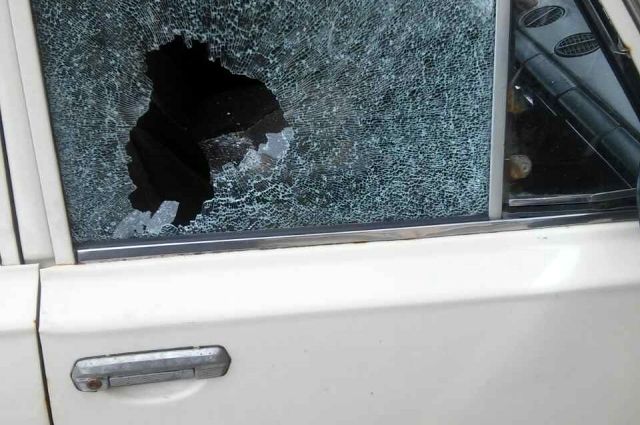 Разбили машину камнем. Хулиган разбивает стекло. Камень на автомобиль. Камнем разбил стекло машины.