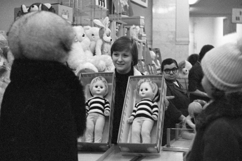 1979 год. Продавец торговой фирмы «Детский мир» предлагает покупательницам выбрать кукол.
