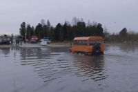 В Надыме людей через затопленный участок дороги перевозит автомобиль "Урал".