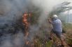 Мужчина в шлеме пытается самостоятельно бороться с огнём в районе Каштаньейра-ди-Пера. 