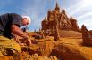 22 июня. Франко Дага из Италии работает над созданием скульптуры из песка во время фестиваля Disney Sand Magic в Остенде, Бельгия.