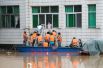 Спасатели эвакуируют людей на лодке во время наводнения в округе Синьшао, провинция Хунань.