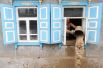 Мужчина вычерпывает воду из жилого дома, пострадавшего от наводнения в городе Крымск в Краснодарском крае.