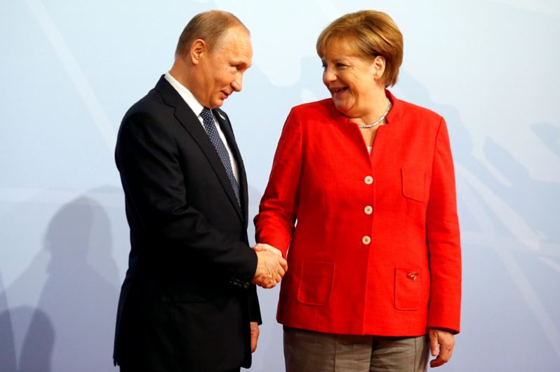 Канцлер Германии Ангела Меркель приветствует президента России Владимира Путина на саммите G20 в Гамбурге.
