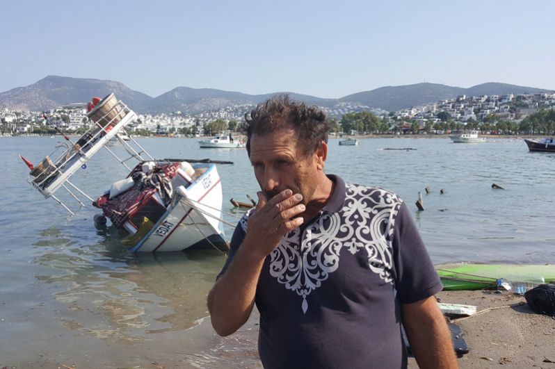 Местный житель после землетрясения в курортном городе Гюмбет в Турции.