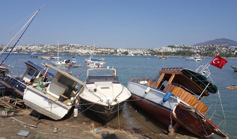 Затопленные лодки после землетрясения и цунами в курортном городе Гюмбет в Турции.
