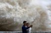 20 июля. Пара фотографируется на фоне тайфуна Талас в провинции Хоа Бинь, Вьетнам.