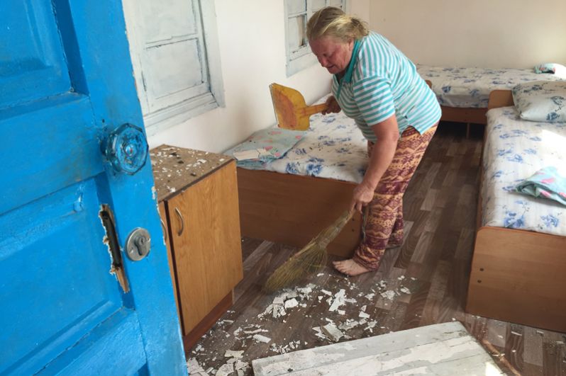 Женщина делает уборку в поврежденном доме в селе Приморское Гудаутского района.