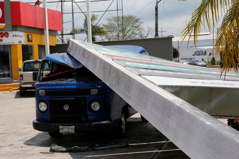 Поврежденный упавшим щитом автомобиль на бензозаправке Pemex после урагана.