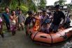 Спасатели эвакуирует жителей деревни, пострадавших от наводнения в районе Калиабор в северо-восточном штате Ассам, Индия.