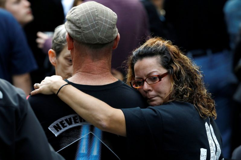 Люди обнимаются в Национальном мемориале и музее 11 сентября во время мероприятий, посвященных 16-й годовщине терактов в Нью-Йорке.
