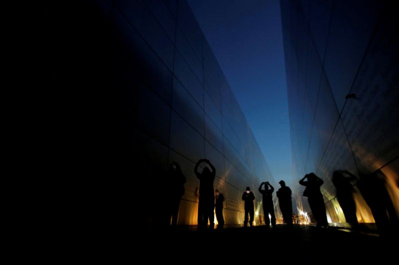 Люди в мемориале «Пустое небо», посвященном 11 сентября. Он представляет собой две стальные стены, символизирующие упавшие башни.