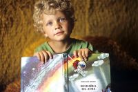 Мальчик с книжкой Н.Носова «Незнайка на луне».