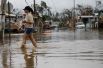 Женщина пробирается через затопленную улицу в Салинасе, Пуэрто-Рико.