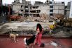 28 сентября. Девочка играет со своими собаками перед разрушенным зданием после землетрясения в Мехико, Мексика.
