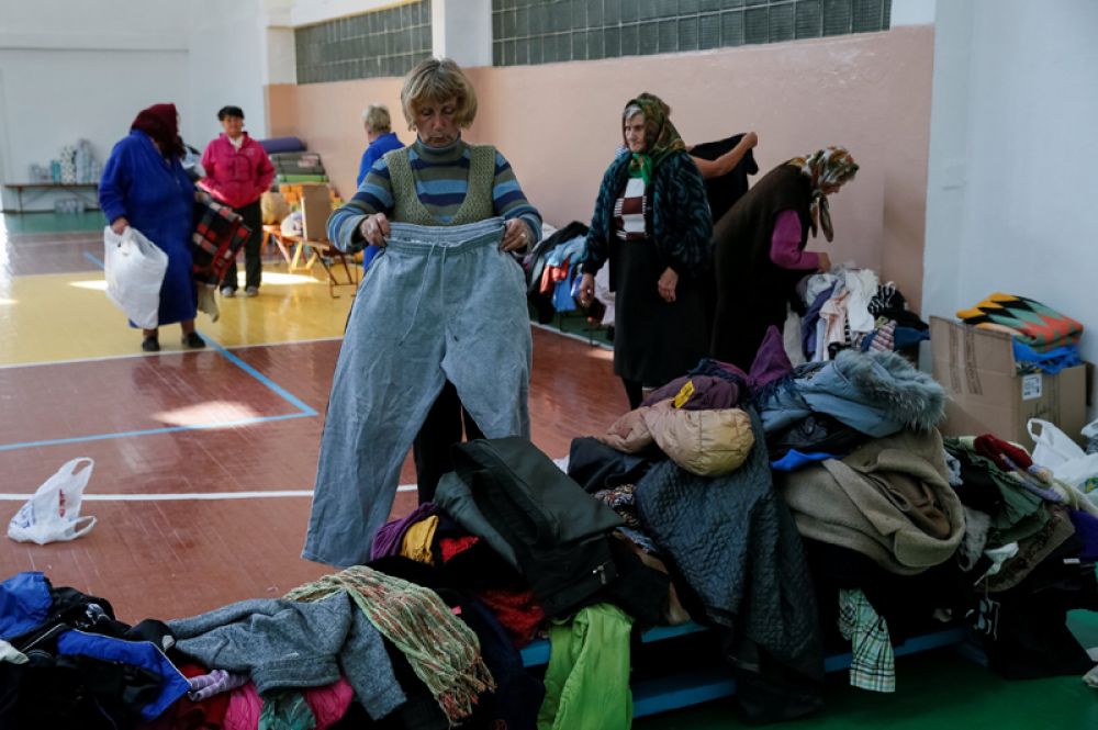 Местные жители, эвакуированные из деревень, расположенных вблизи складов боеприпасов, получают гуманитарную помощь в одной из школ Винницы.