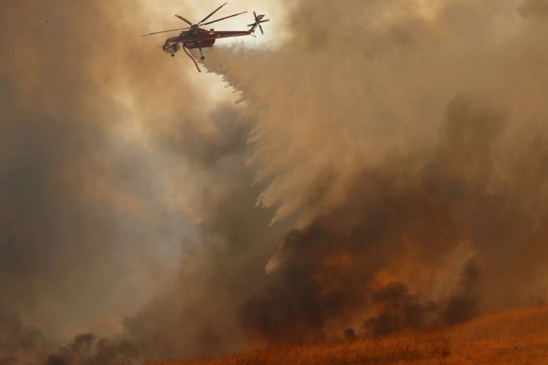 Пожарный вертолет тушит лесной пожар в Ориндже.