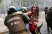 9 октября. Девушка, задержанная во время акции протеста в День Колумба в Сантьяго, Чили.