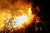 Пожарный тушит огонь около города Лоуса в Португалии.