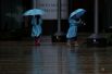 Дети гуляют под сильным дождем в Токио, в то время как тайфун «Лан» подходит к материковой части Японии.