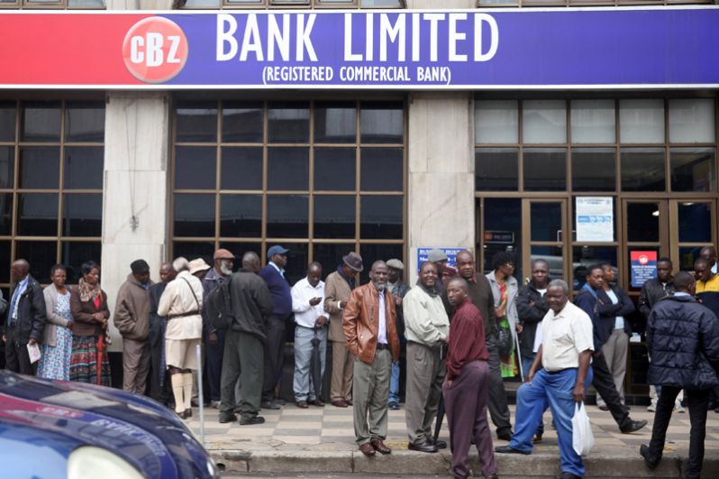 Местные жители стоят в очереди к банку, чтобы снять деньги.
