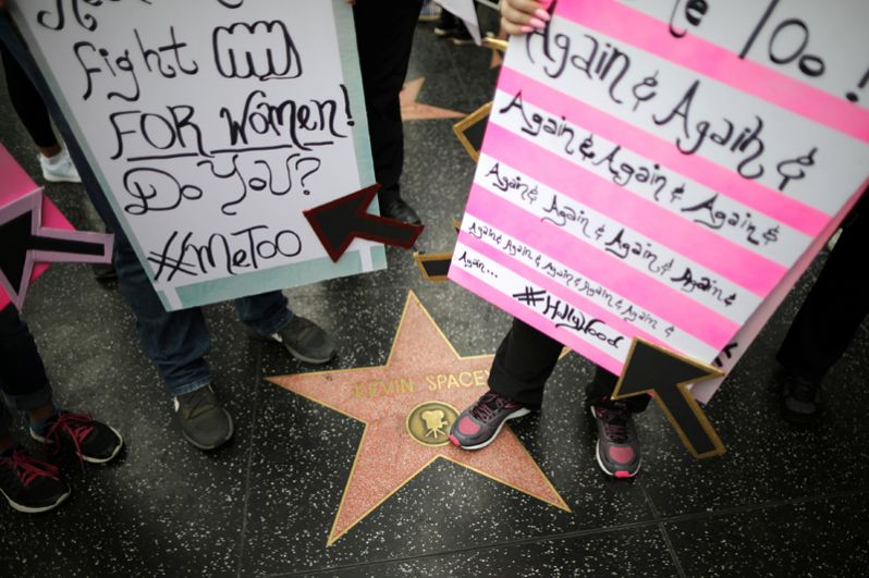 Демонстранты рядом со звездой актёра Кевина Спейси на Голливудской аллее славы.