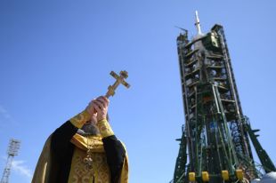 Священнослужитель проводит обряд освящения ракеты-носителя «Союз-ФГ» с пилотируемым кораблем «Союз МС-06» перед запуском на космодроме «Байконур».